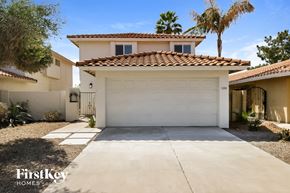 Mesa house for rent - a white garage door in front of a house with palm trees