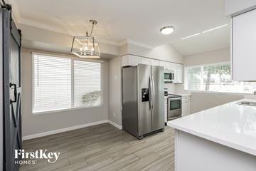 Mesa house for rent - a white kitchen with stainless steel appliances and a white counter top