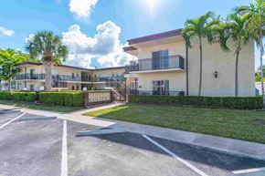 Hollywood apartment for rent - an empty parking lot in front of an apartment building with palm trees