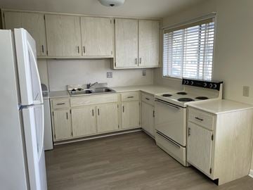Kettering apartment for rent - a kitchen with white cabinets and a stove and a refrigerator