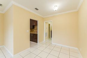 Hollywood apartment for rent - A room with a white tile floor and a doorway leading to another room.