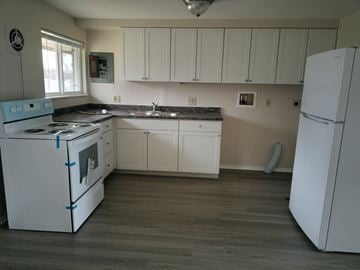 Kettering apartment for rent - an empty kitchen with white appliances and white cabinets