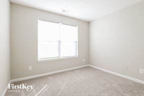 Fuquay-Varina house for rent - a bedroom with a large window and a carpeted floor