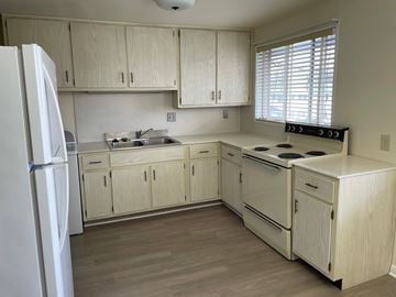 Kettering apartment for rent - a kitchen with white cabinets and a stove and a refrigerator