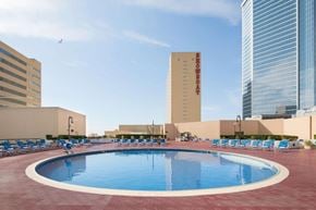 Atlantic City apartment for rent - A round swimming pool surrounded by chairs in the middle of a city.