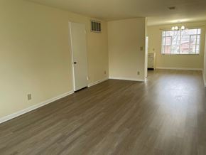 Kettering apartment for rent - A room with light wood flooring and a window with blinds.