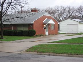 Kettering apartment for rent - a brick house with a white garage door and a sidewalk