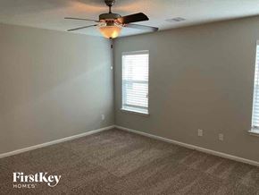 Katy house for rent - A room with a carpet floor and a ceiling fan.