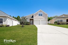 Kissimmee house for rent - A white house with a driveway in front of it.