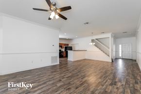 Kissimmee house for rent - A spacious room with wooden floors and a ceiling fan.