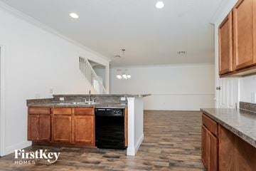 Kissimmee house for rent - A kitchen with wooden cabinets and a granite countertop.