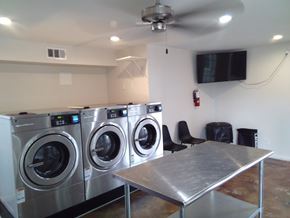 Pasadena apartment for rent - A room with a washer and dryer on the wall and a table in the middle.