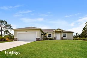 Port Charlotte house for rent - a house with a lawn and a garage door