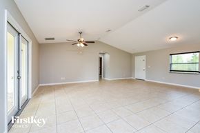 Port Charlotte house for rent - an empty living room with tile flooring and a ceiling fan