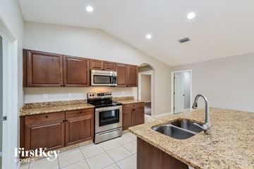 Port Charlotte house for rent - a kitchen with granite counter tops and wooden cabinets