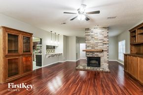 Spring house for rent - A spacious living room with wood floors and a stone fireplace.