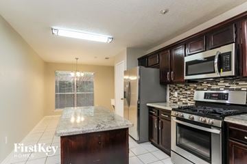 Spring house for rent - A kitchen with a granite countertop and stainless steel appliances.