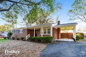 Gastonia house for rent - a brick house with a covered porch and a driveway