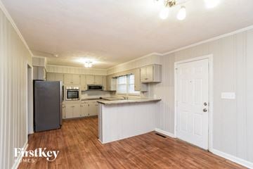 Gastonia house for rent - a kitchen with white cabinets and a counter top