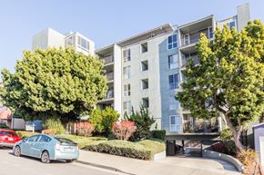 Oakland apartment for rent - A blue car is parked in front of a modern apartment building.