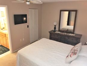 Bradenton house for rent - the master bedroom has a large bed and a tv