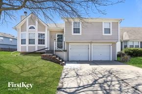 Kansas City house for rent - a white house with two garage doors and a driveway