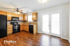 Kansas City house for rent - a kitchen with wood flooring and wooden cabinets and a window