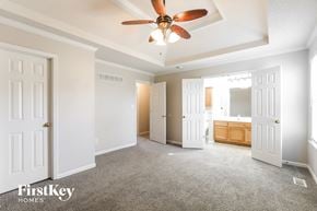 Kansas City house for rent - a master bedroom with a ceiling fan and a bathroom