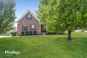 Monroe house for rent - a large lawn in front of a brick house with a tree