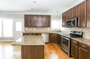 Monroe house for rent - a kitchen with wooden cabinets and granite counter tops