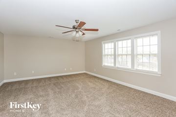 Monroe house for rent - a living room with carpet and a ceiling fan