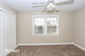 Monroe house for rent - a bedroom with a ceiling fan and a window