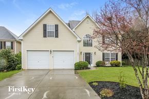 Denver house for rent - a beige house with white doors and a driveway
