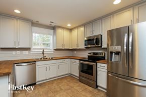 Denver house for rent - a kitchen with stainless steel appliances and white cabinets