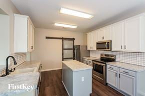 Fort Worth house for rent - a kitchen with white cabinets and stainless steel appliances