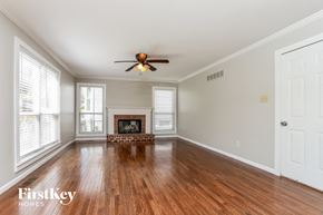 Fenton house for rent - A spacious room with a fireplace and a ceiling fan.