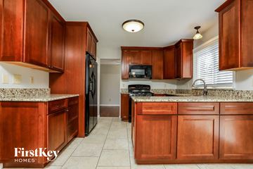 Fenton house for rent - A kitchen with wooden cabinets and a granite countertop.