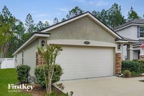 Orange Park house for rent - a home with a white garage door and a driveway