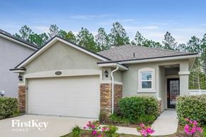 Orange Park house for rent - a beige house with a white door and a driveway