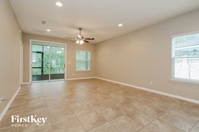 Orange Park house for rent - an empty living room with a ceiling fan and a window