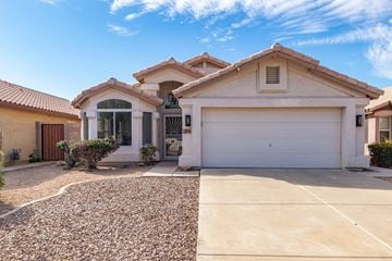 Peoria house for rent - A house with a white garage door and a brown roof.