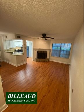 Lafayette house for rent - A room with a fireplace and a ceiling fan.