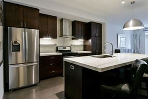 Minneapolis apartment for rent - A modern kitchen with dark wood cabinets and a stainless steel refrigerator.