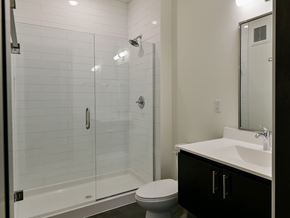 Minneapolis apartment for rent - A white toilet sits in a bathroom next to a walk-in shower.