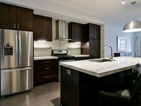 Minneapolis apartment for rent - A modern kitchen with a stainless steel refrigerator and dark brown cabinets.