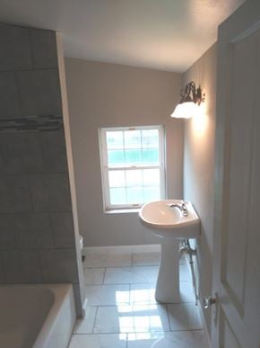 Cincinnati house for rent - A white pedestal sink in a bathroom with a window.