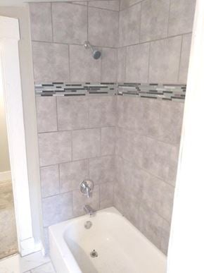 Cincinnati house for rent - A white bathtub with a shower head and faucet.
