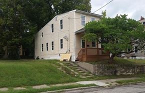 Cincinnati house for rent - A white house with a brown porch and a tree in front.