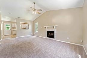 Jacksonville house for rent - A living room with a fireplace and a ceiling fan.