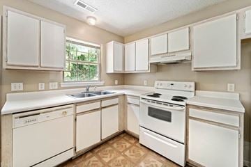 Jacksonville house for rent - A kitchen with white appliances and cabinets.